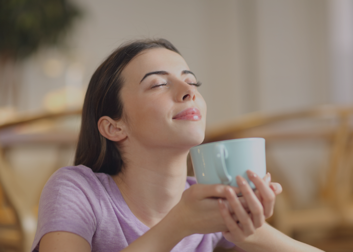 Eine Frau genießt eine ruhige Pause mit einer Tasse Tee, ein Bild, das Riech- und Geschmackstests symbolisiert, um die Sinne zu überprüfen und den Genuss an alltäglichen Dingen wie dem Geschmack von Tee zu bewerten. Diese Tests sind Teil der umfassenden Diagnostik in der HNO-Praxis.