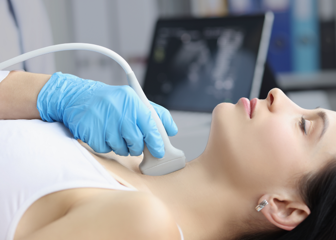 Ein Arzt führt eine Ultraschalluntersuchung an der Halsregion einer Patientin durch, typischerweise zur Überprüfung der Schilddrüse.